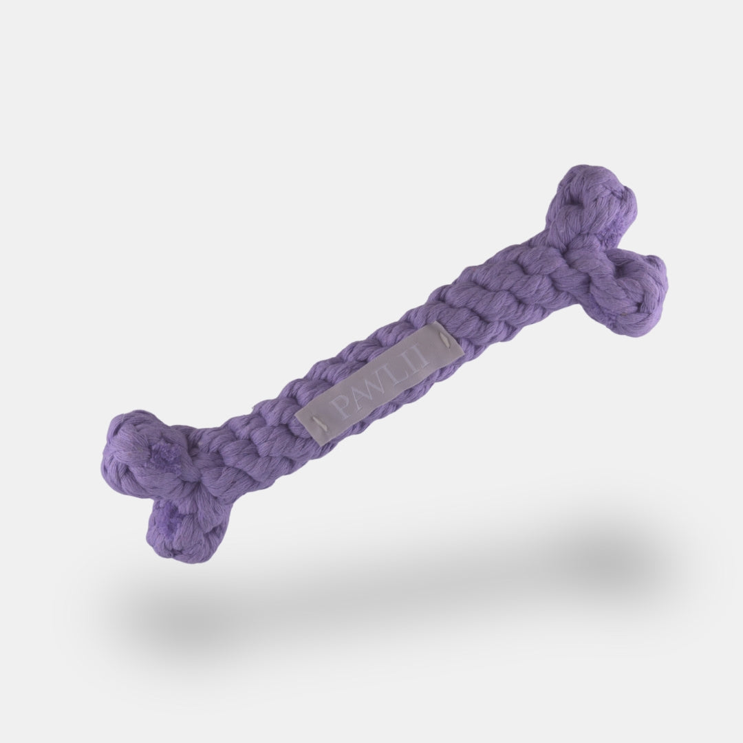 Kauspielzeug aus Baumwolle in Form eines Knochen in der Farbe lila.